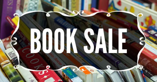 background of books on a shelf with "book sale" written in white over it 